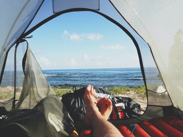 feet facing the sea while camping