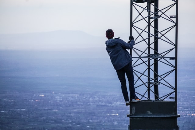 man holding onto side of satellite